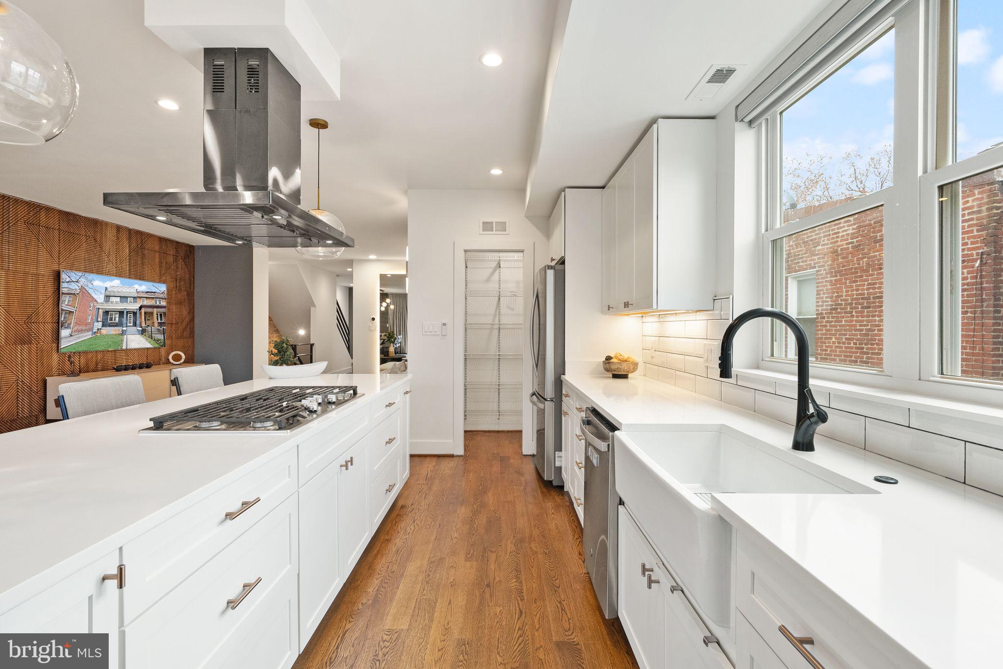 117 17th Street Southeast, Unit 2 Washington, DC 20003 - Photo 10 of 31 a large white kitchen with a large window a sink and stainless steel appliances