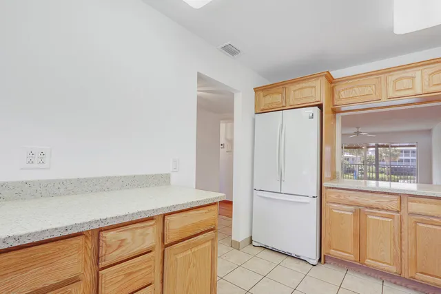 a kitchen with white cabinets and refrigerator