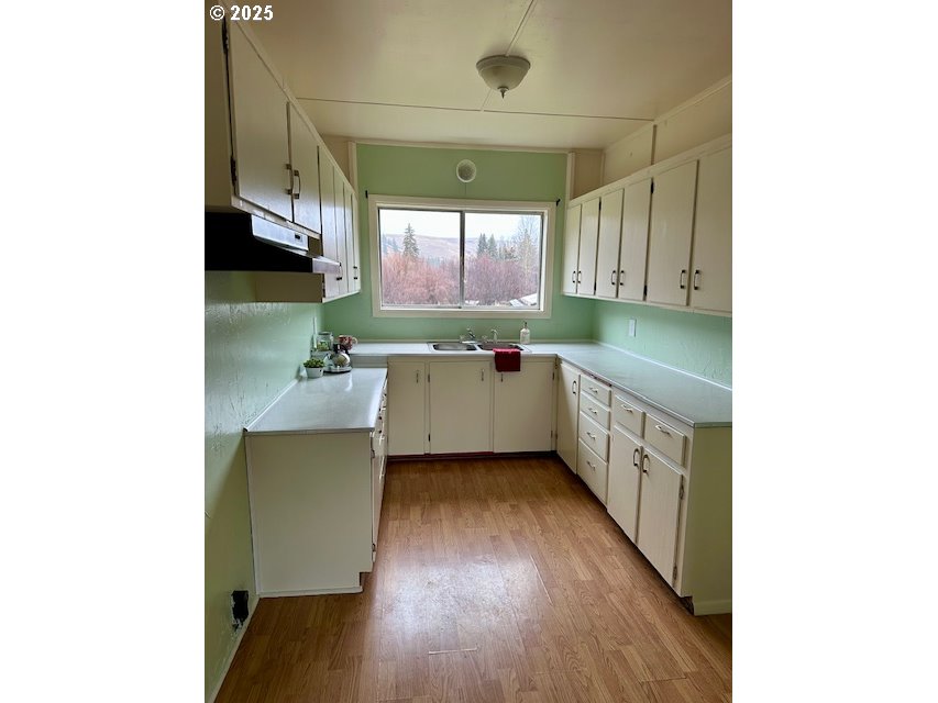 62254 Wallowa Mtn Loop Road Joseph, OR 97846 - Photo 32 of 35 a kitchen with a sink and wooden floor