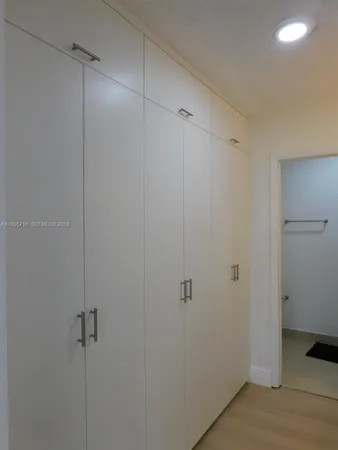 a white toilet sitting next to a white wall