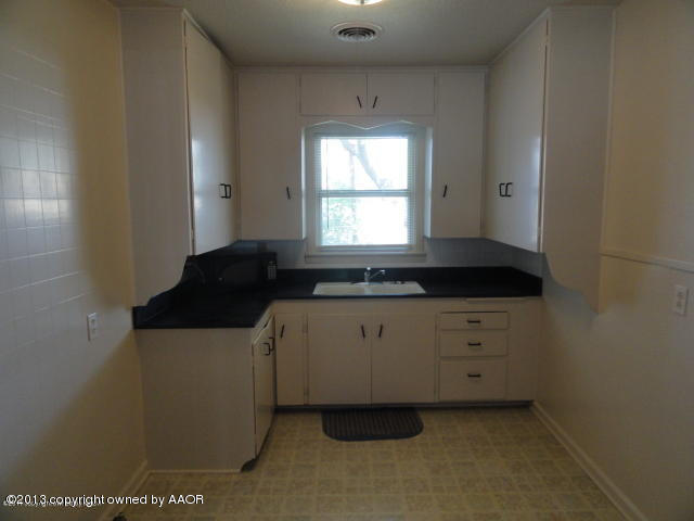 4002 South Jackson Street Amarillo, TX 79110 - Photo 4 of 9 a kitchen with granite countertop white cabinets and sink