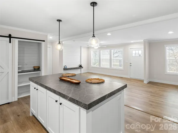 a kitchen with stainless steel appliances granite countertop a sink a stove a refrigerator and island with wooden floor