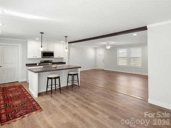 a view of kitchen with sink microwave and cabinets