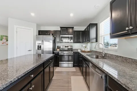a kitchen with granite countertop stainless steel appliances and wooden cabinets