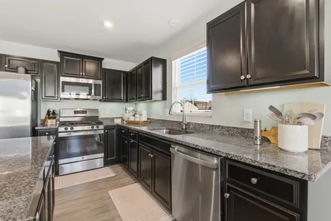 a kitchen with granite countertop stainless steel appliances and wooden cabinets