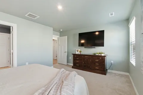 a bedroom with a bed and a flat screen tv