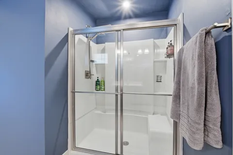 a bathroom with a glass shower door and a mirror