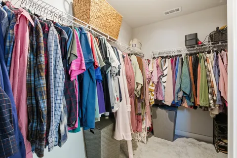 a view of walk in closet with clothes
