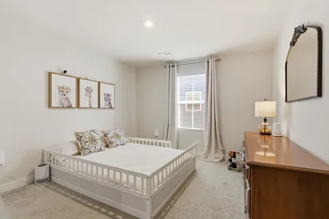 a spacious bedroom with a bed and wooden floor