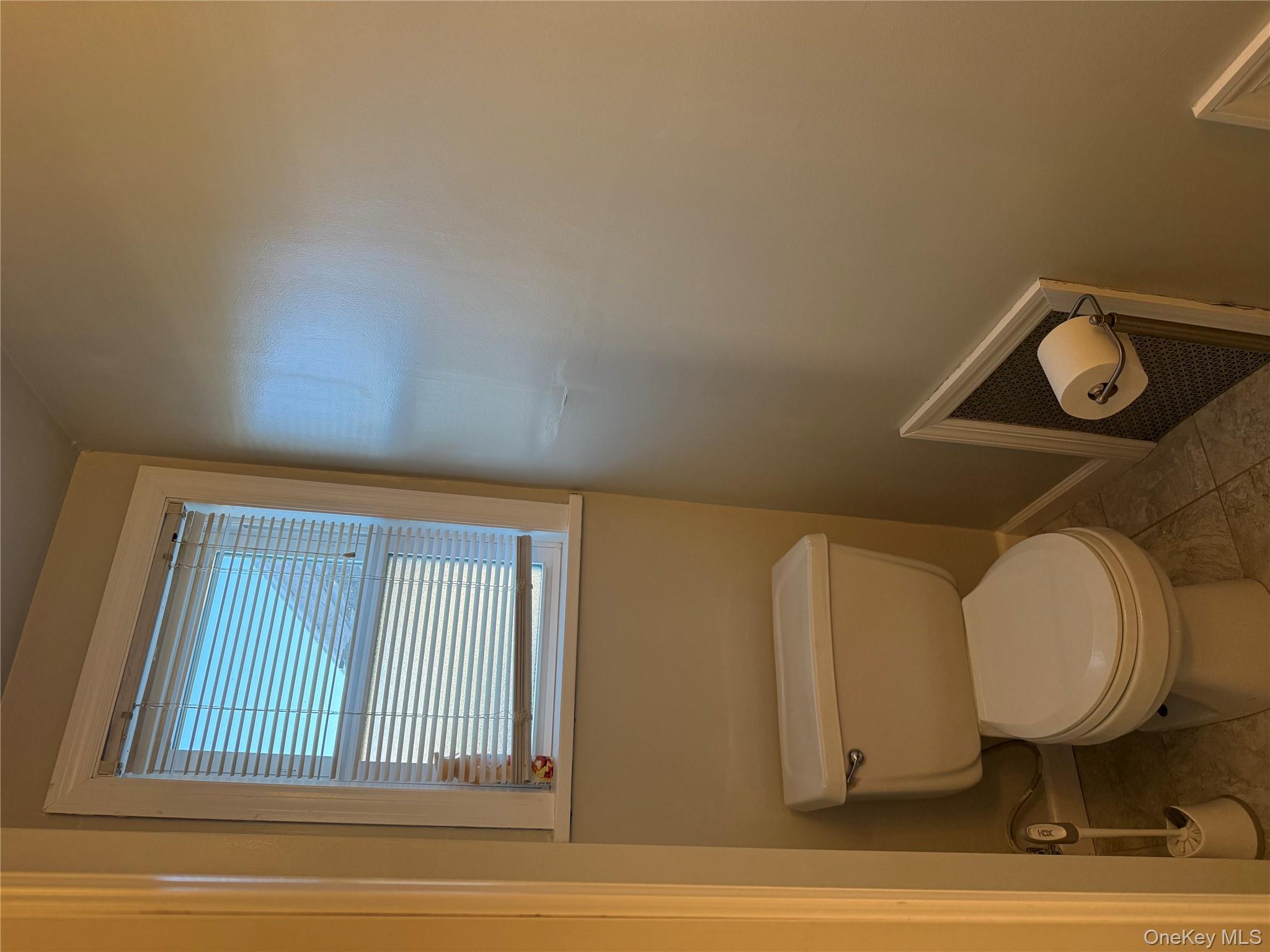 55 Lester Avenue Freeport, NY 11520 - Photo 14 of 38 a white toilet sitting next to a window