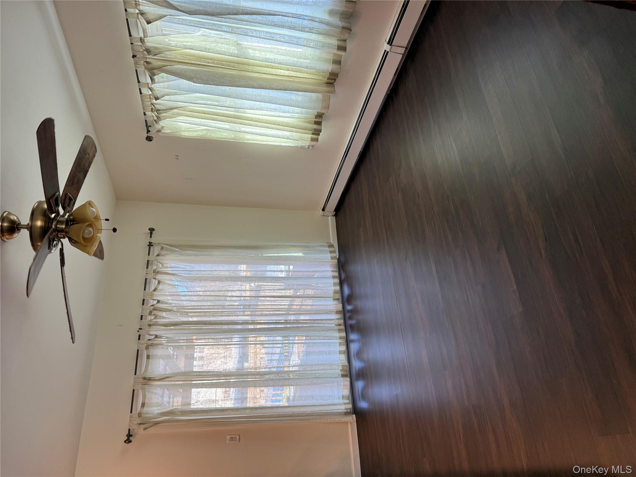 55 Lester Avenue Freeport, NY 11520 - Photo 7 of 38 an empty room with wooden floor fan and windows