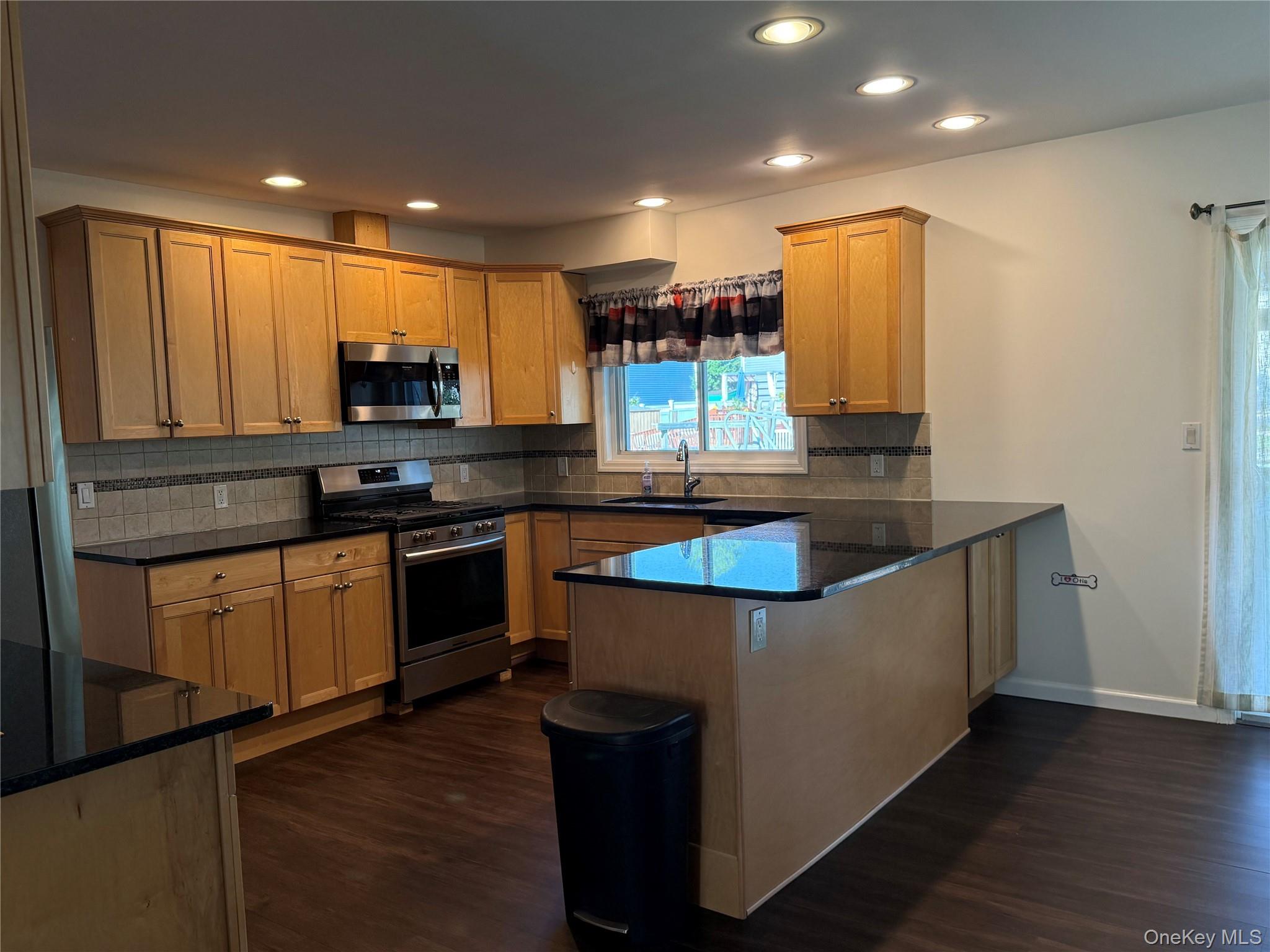 55 Lester Avenue Freeport, NY 11520 - Photo 10 of 38 a kitchen with stainless steel appliances granite countertop a stove a sink and a refrigerator