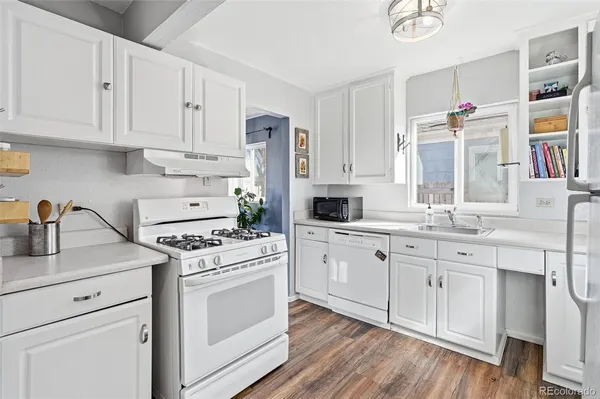a kitchen with white cabinets and white appliances