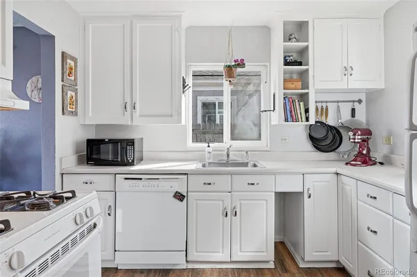 a kitchen with white cabinets and appliances