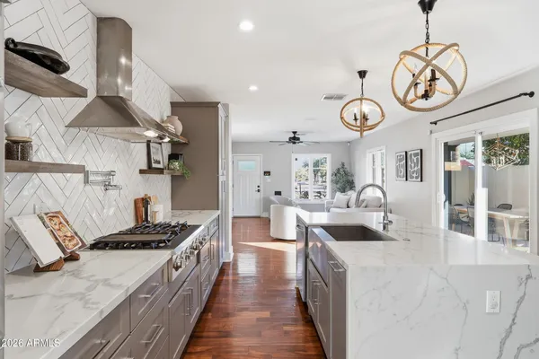 a large kitchen with stainless steel appliances granite countertop a lot of counter space and wooden floor