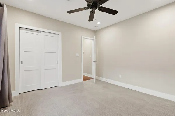 en empty room with windows and ceiling fan