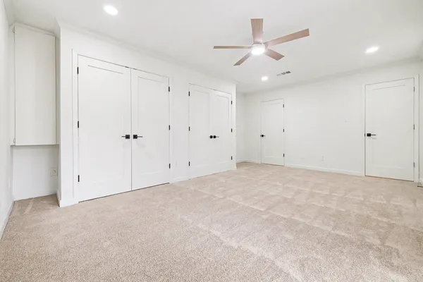 an empty room with ceiling fan and window