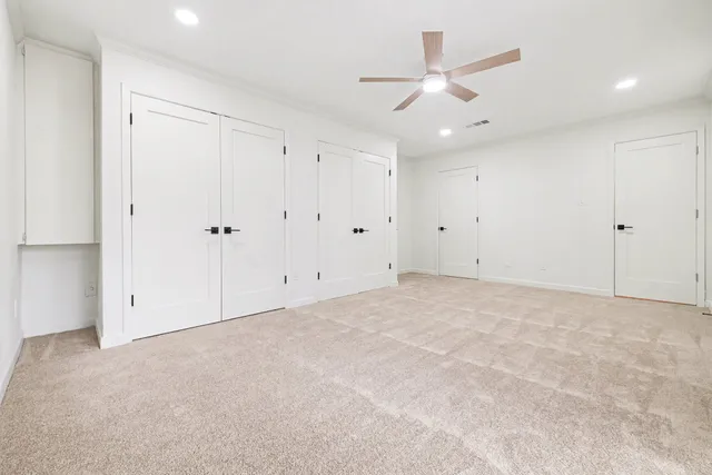 an empty room with ceiling fan and window