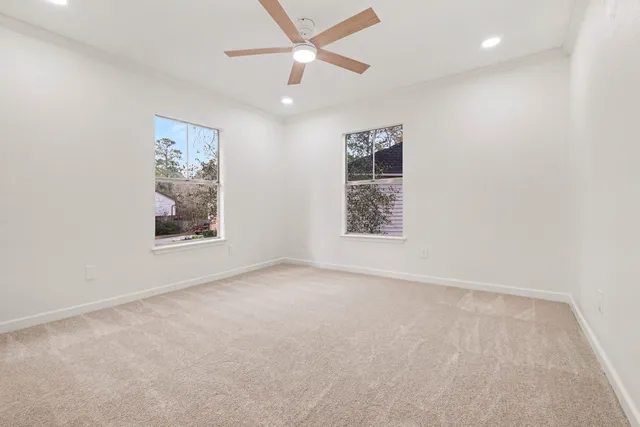 an empty room with windows and fan