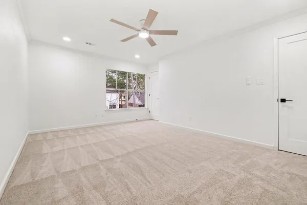 an empty room with fan and windows