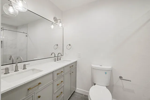 a bathroom with a granite countertop toilet sink and mirror