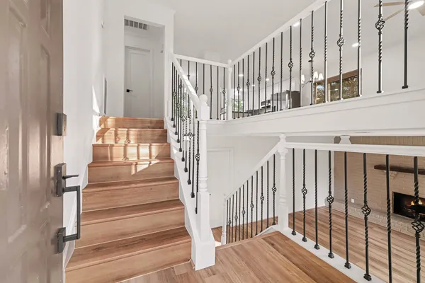 a view of staircase with lots of frames on wall and a window