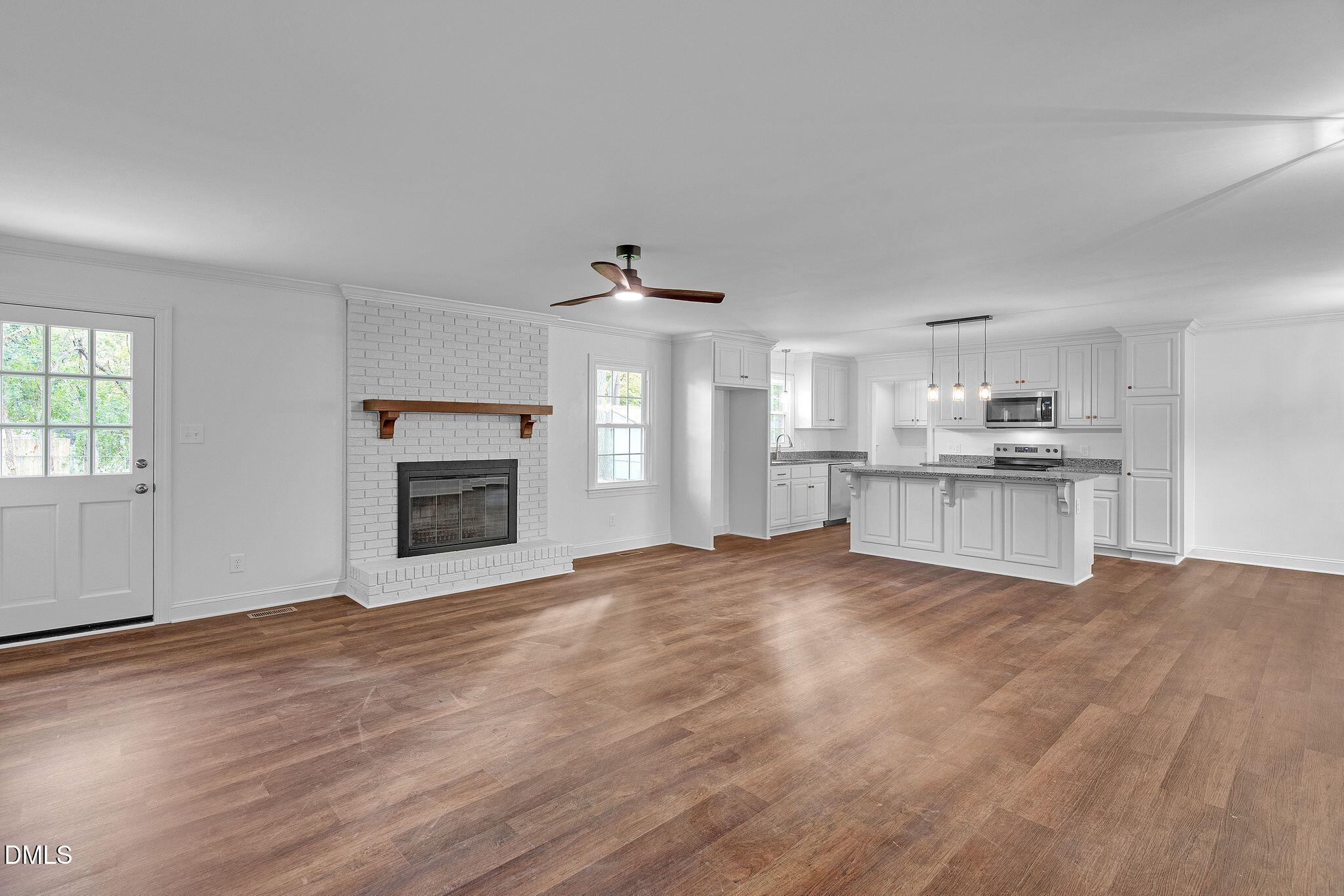 1219 Queen Anne Road Northwest Wilson, NC 27896 - Photo 4 of 26 a view of kitchen and empty room with wooden floor
