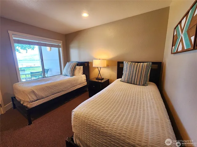 a bedroom with two beds and painting on the wall