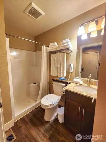 a bathroom with a sink toilet a mirror and shower