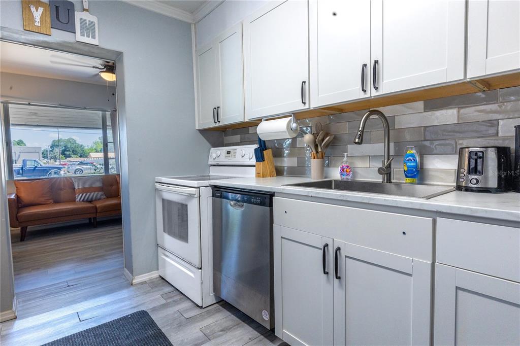 123 Oconee Street Lakeland, FL 33805 - Photo 12 of 25 a kitchen with stainless steel appliances white cabinets and a wooden floor