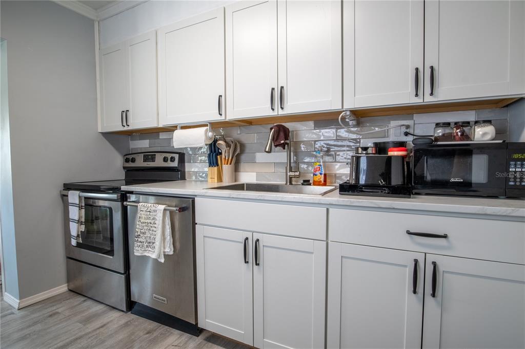 123 Oconee Street Lakeland, FL 33805 - Photo 13 of 25 a kitchen with stainless steel appliances granite countertop a stove and a white cabinets