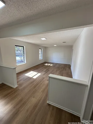 a view of an empty room and wooden floor