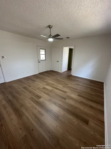 en empty room with windows and ceiling fan