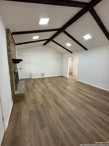 a view of empty room with wooden floor