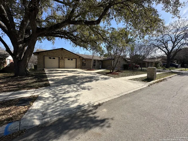 a front view of a house with a yard covered with snow