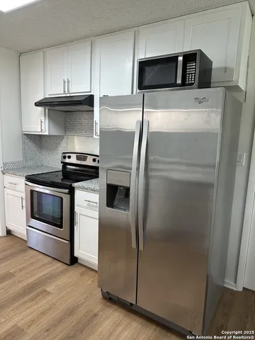 a kitchen with stainless steel appliances a refrigerator a stove and a sink
