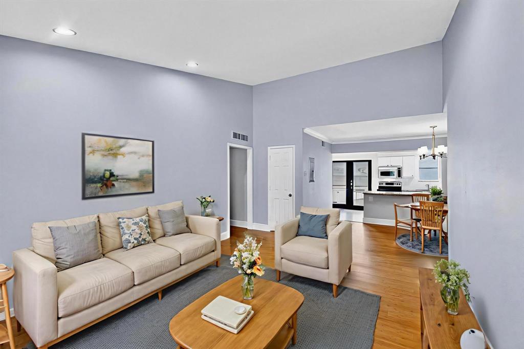 Virtually staged living area with light wood-style flooring, a chandelier, and recessed lighting