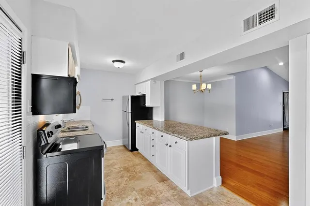 a kitchen with stainless steel appliances kitchen island granite countertop a stove and a microwave