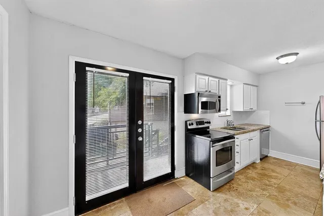 a kitchen with stainless steel appliances granite countertop a stove a refrigerator and a sink