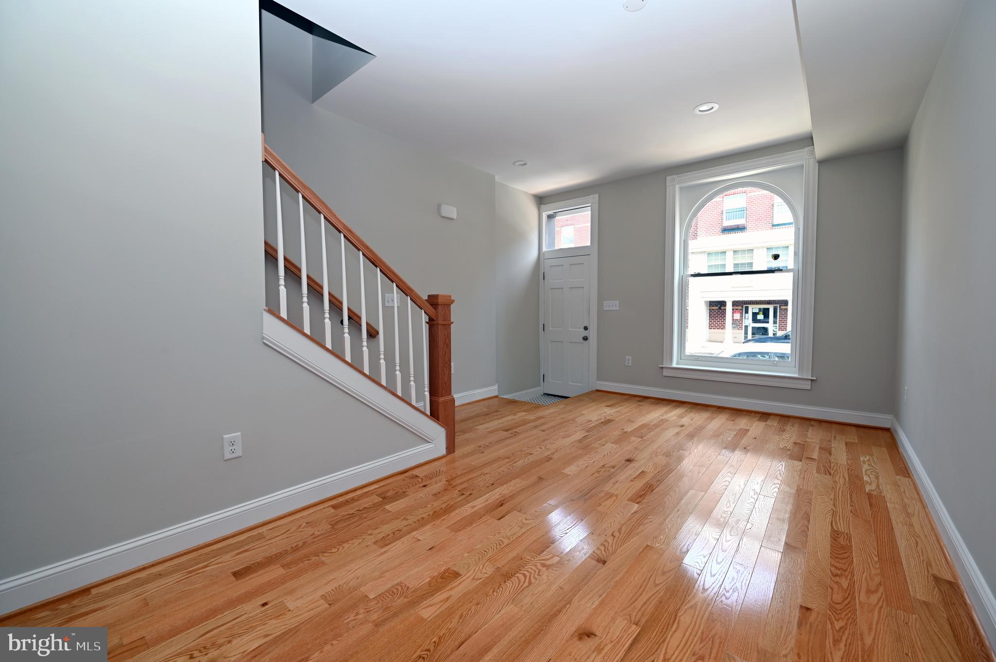 2245 East Biddle Street Baltimore, MD 21213 - Photo 7 of 14 a view of an empty room with window and wooden floor