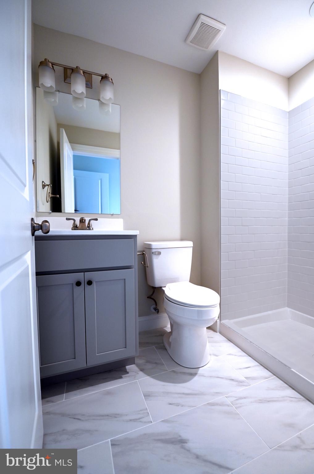 2245 East Biddle Street Baltimore, MD 21213 - Photo 8 of 14 a bathroom with a toilet a sink and mirror