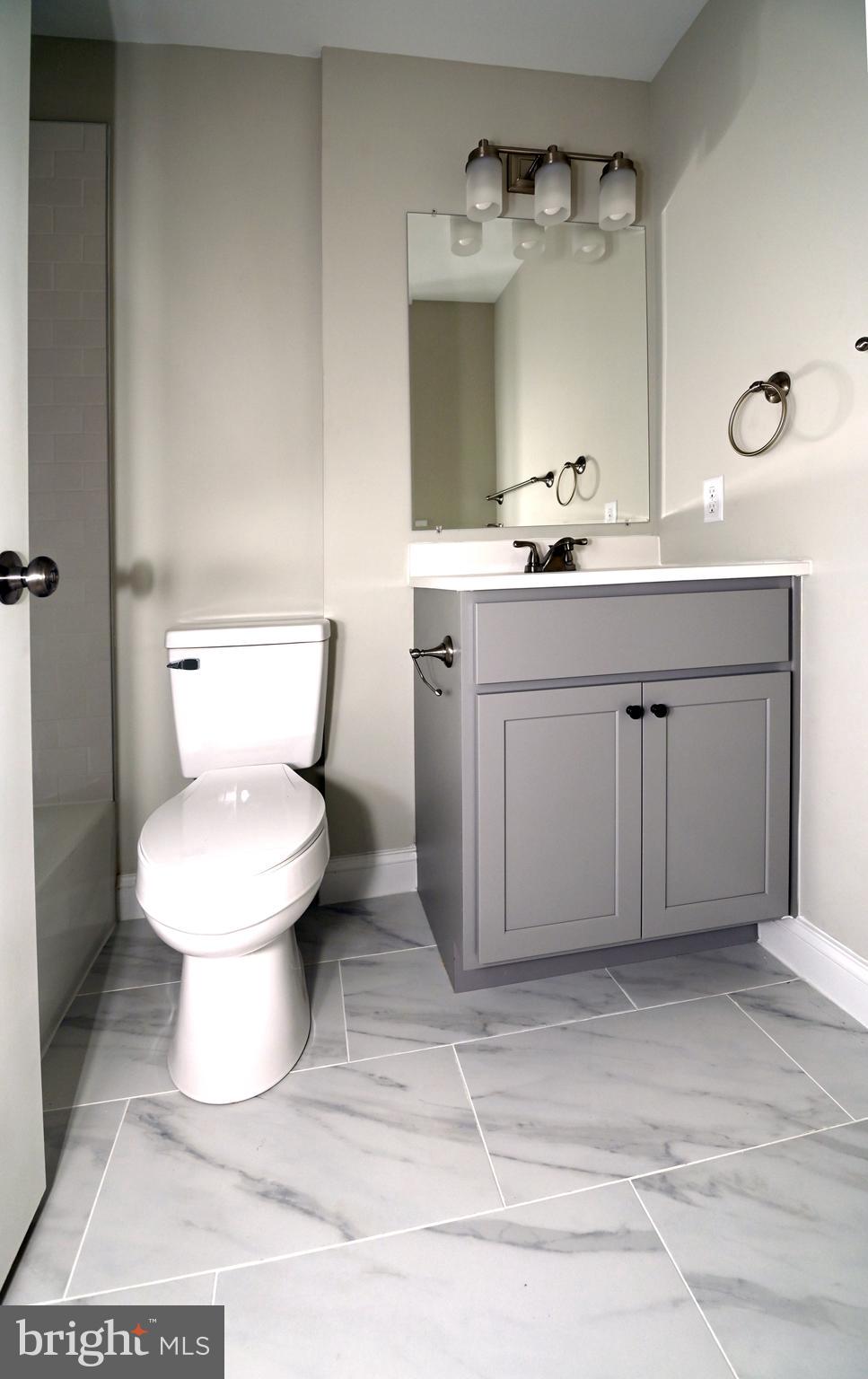 2245 East Biddle Street Baltimore, MD 21213 - Photo 9 of 14 a bathroom with a sink toilet and mirror