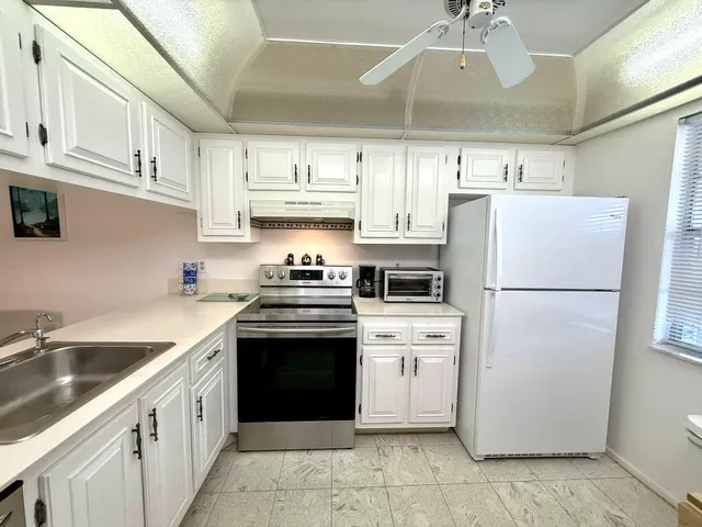 a kitchen with stainless steel appliances a refrigerator sink and cabinets