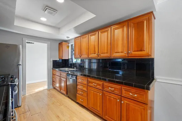 a kitchen with stainless steel appliances granite countertop wooden cabinets a sink and a large window