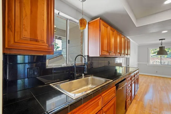 a kitchen with stainless steel appliances granite countertop a sink a stove and cabinets