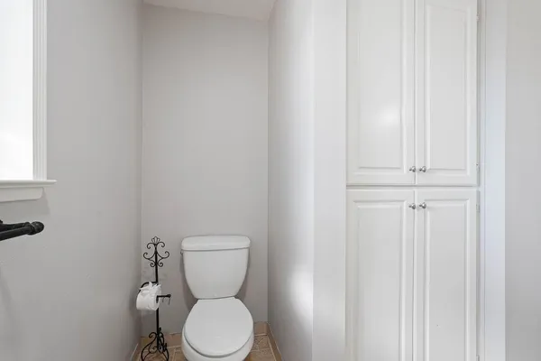 a white toilet sitting next to a white cabinet