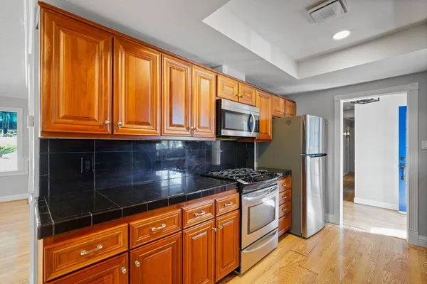a kitchen with stainless steel appliances granite countertop a refrigerator and a stove top oven