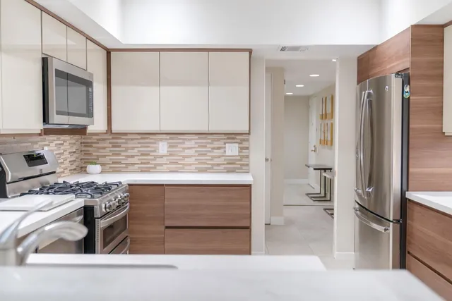 a kitchen with stainless steel appliances granite countertop a stove and a refrigerator