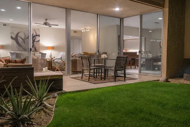 a living room with furniture a large window and a dining table