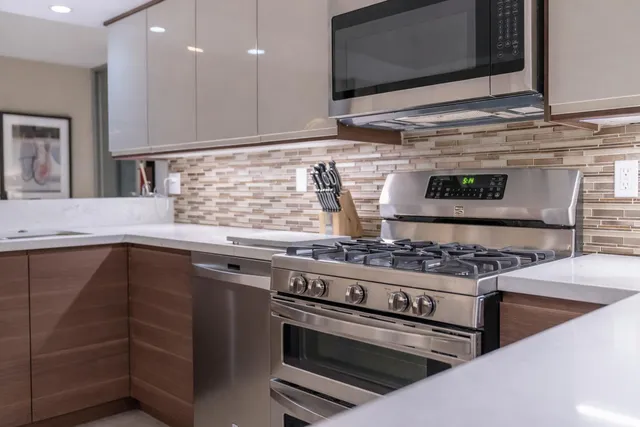 a kitchen with stainless steel appliances granite countertop a stove and a sink